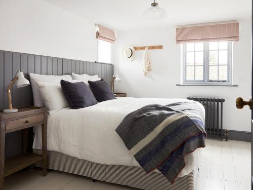 a bedroom with a bed and a wooden nightstand with a bed sidx sidx sidx at Eden Hall Cottage in Bacton