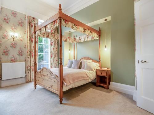 a bedroom with a canopy bed and a window at The Old Ballroom in Norwich