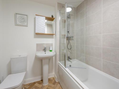 La salle de bains est pourvue d'un lavabo, d'une baignoire et de toilettes. dans l'établissement Haras House, à Tiverton
