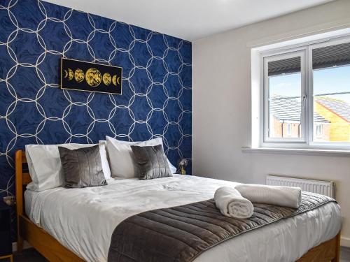 1 dormitorio con 1 cama con pared azul en Gadebridge, en Thornaby on Tees