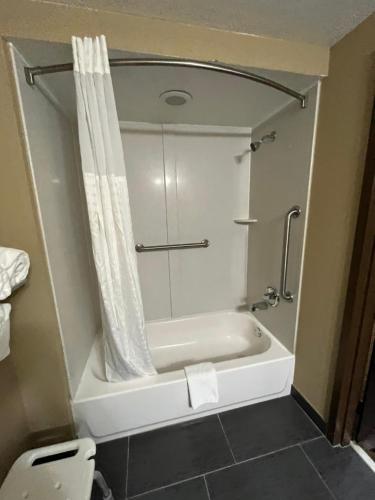 a bathroom with a bath tub and a toilet at Quality Suites in Graham