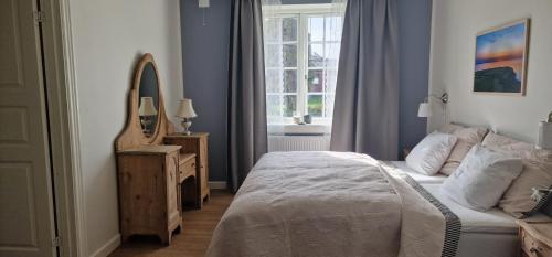 a bedroom with a bed and a mirror and a window at Hotel Udsigten Marstal in Marstal