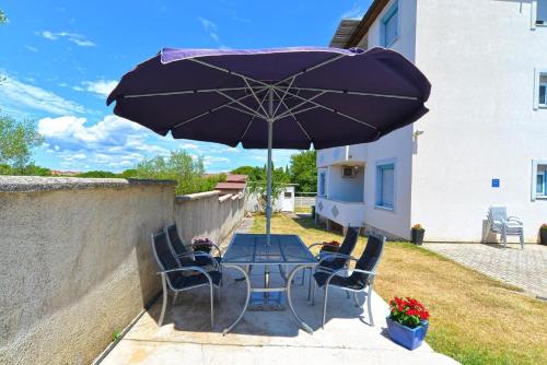 - une table avec des chaises et un parasol sur la terrasse dans l'établissement Ferienwohnung für 3 Personen ca 30 qm in Fažana-Surida, Istrien Istrische Riviera - b62503, à Štinjan