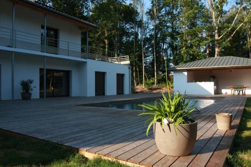 a wooden deck next to a house with a swimming pool at Lazuli Lodge in Azur