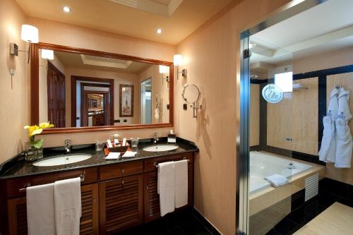 a bathroom with two sinks and a tub and a mirror at Elba Estepona Gran Hotel & Thalasso Spa in Estepona