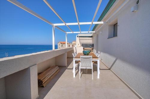 uma varanda com uma mesa e cadeiras e o oceano em Ferienwohnung für 5 Personen ca 110 qm in Cefalù, Sizilien Nordküste von Sizilien em Cefalù