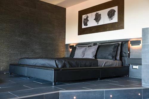 a black bed in a room with a brick wall at Suite 115 - Luxury Rooms in Capoterra