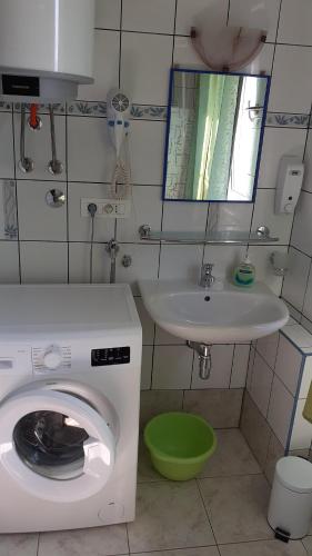 a bathroom with a washing machine and a sink at Kuća - Krčina in Cres
