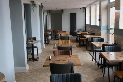 uma sala de jantar com mesas e cadeiras de madeira em Balmoral Hotel em Blackpool