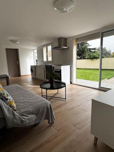 a living room with a bed and a table in a room at Maison entièrement Neuve in Marseille