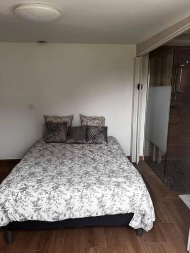 una camera da letto con un letto con un piumone e cuscini di Maison entièrement Neuve a Marsiglia