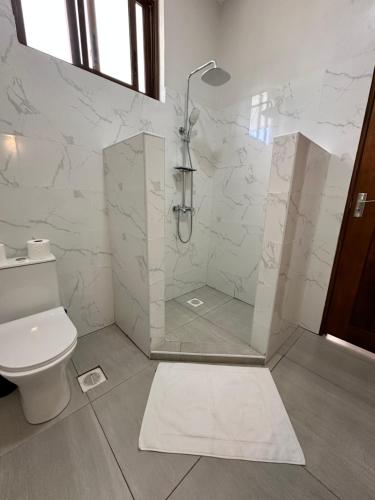een badkamer met een douche en een toilet bij YU Resort in Msambweni