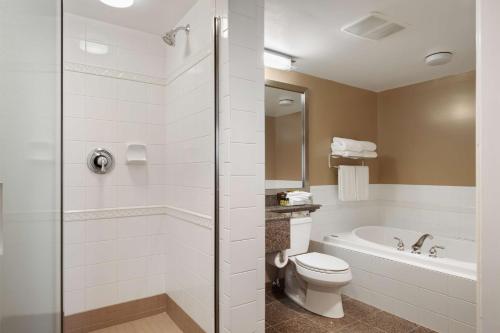 Best Western Plus Columbia River Hotel في Trail: حمام مع حوض استحمام ومرحاض ودش