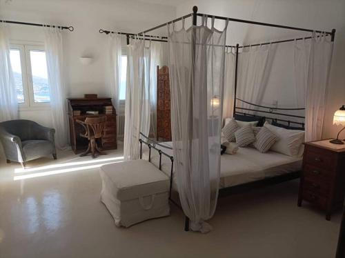 a bedroom with a canopy bed and a desk at Koundouros Petra house in Koundouros