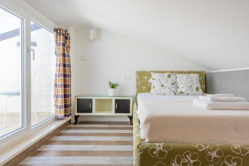 sypialnia z łóżkiem i dużym oknem w obiekcie Residenza Verdeoliva - YourPlace Abruzzo w mieście Rocca San Giovanni