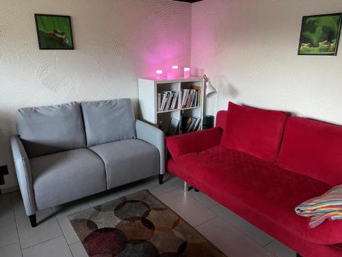 una sala de estar con 2 sofás y un sofá rojo. en Ferienhaus am Listersee en Meinerzhagen