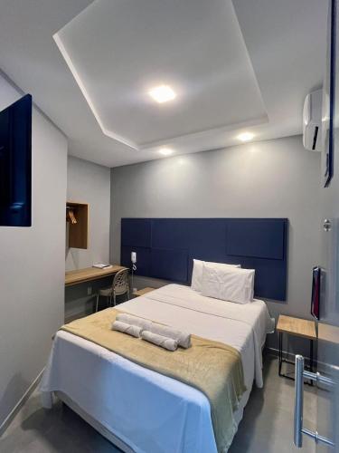a bedroom with a large bed with two towels on it at Hotel Place Jardin in Garanhuns