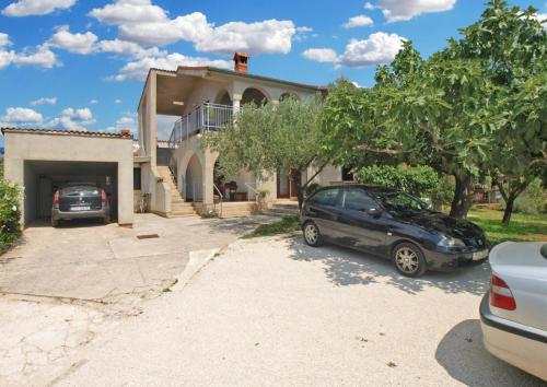 una casa con dos coches aparcados en una entrada en Ferienwohnung für 4 Personen ca 42 qm in Fažana, Istrien Istrische Riviera - b62492, en Fažana