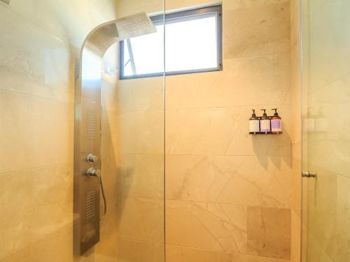 a shower with a glass door in a bathroom at Tribu Sonata with pool in Guadalajara