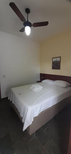 sypialnia z łóżkiem i wentylatorem sufitowym w obiekcie Solaris do Atlantico w mieście Ilhéus