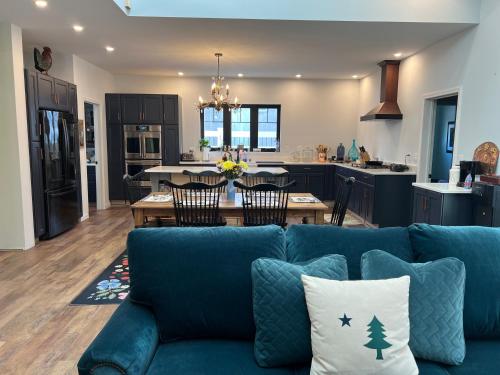 a living room with a blue couch and a kitchen at Canterbury Suites B&B in Bar Harbor