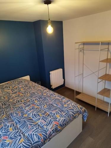 a bedroom with a bed and a blue wall at Location saisonnière Cravant Deux Rivières 89460 in Cravant