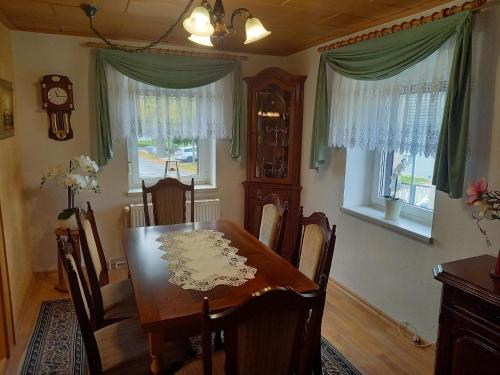 comedor con mesa, sillas y ventanas en Appartement in Zescha mit Terrasse und Garten en Neschwitz