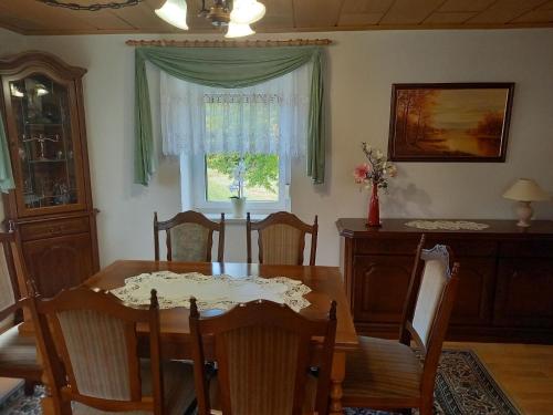 comedor con mesa, sillas y ventana en Appartement in Zescha mit Terrasse und Garten en Neschwitz