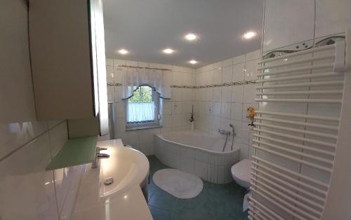 baño blanco con bañera, aseo y lavamanos en Appartement in Zescha mit Terrasse und Garten en Neschwitz