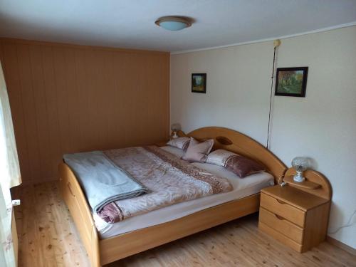 1 cama con marco de madera en un dormitorio en Appartement in Zescha mit Terrasse und Garten en Neschwitz