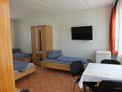 PruchtenにあるBungalow 1のベッド2台、壁掛けテレビが備わる客室です。