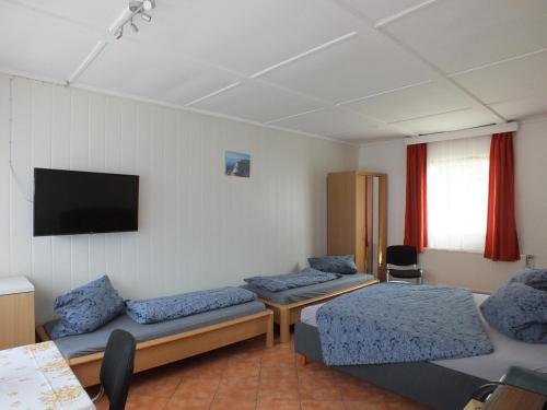 a room with two beds and a flat screen tv at Bungalow 1 in Pruchten