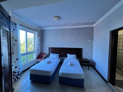 Habitación de hotel con 2 camas y ventana en Ocean Blue Retreat-3 minute walk to Nyali Center and 3 minute walk to the Beach, en Mombasa