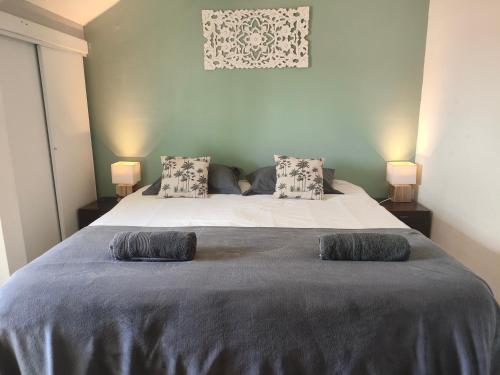 a bedroom with a large bed with two pillows at Paradise Duplex avec piscine et accés Plage in Le Gosier