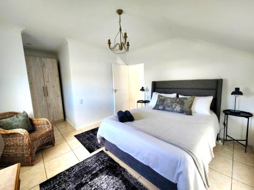 a bedroom with a large bed and a chair at This Is Not The Post Office in Riebeek-Kasteel