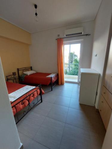 a small room with two beds and a window at SANTA MAURA in Lefkada Town