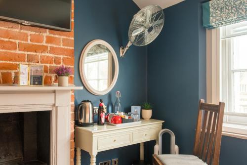 a room with a fireplace and a mirror at The Westgate in Winchester