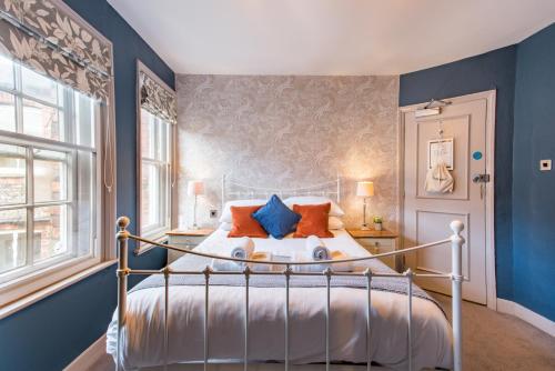 una camera da letto con un letto con pareti blu e una finestra di The Westgate a Winchester