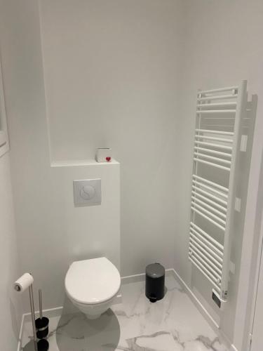 La salle de bains blanche est pourvue de toilettes. dans l'établissement Appartement 3 pièces rénové, à Beausoleil