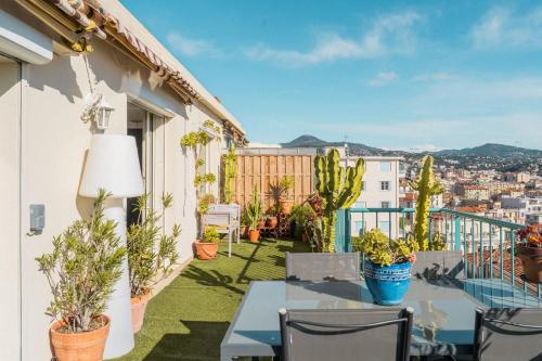 d'un balcon avec une table, des chaises et des plantes. dans l'établissement Magnifique toit terrasse 2 chambres Nice Centre, à Nice