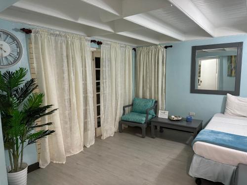奧喬里奧斯的住宿－Coral Cozy，一间卧室配有一张床、一把椅子和闹钟