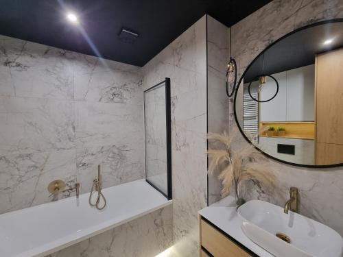 uma casa de banho com um lavatório e um espelho em Sky Apart W21 em Lódź