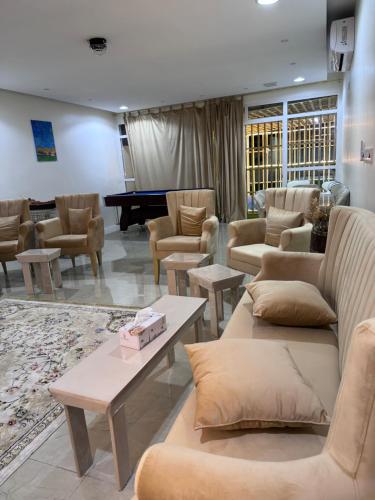 a living room with couches and tables and a piano at استراحة زمردة in Khasab