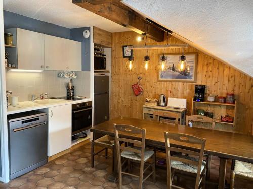 a kitchen with a wooden table and chairs in it at Résidence Betelgeuse - 3 Pièces pour 5 Personnes 004 in Valloire