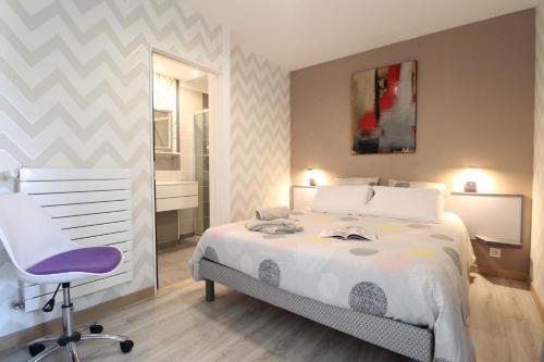 een slaapkamer met een wit bed en een stoel bij Annexe 43 in Guérande