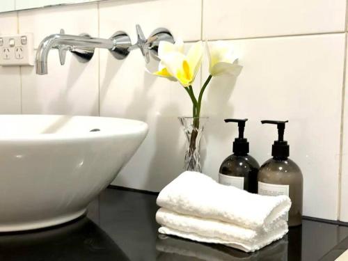 een badkamer met een wastafel en een vaas met bloemen bij Superb Apartment in an Heart of Sydney' CBD in Sydney