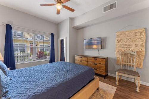 a bedroom with a bed and a tv and a chair at Mickey's Magical Townhome Venetian Bay Villages in Kissimmee