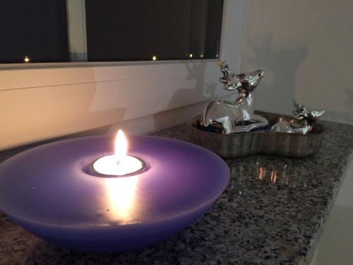 a purple bowl with a candle on a counter at Alpenglück de Luxe Ferienwohnung am Forggensee in Schwangau
