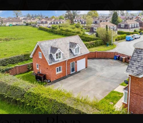 una grande casa in mattoni rossi con un grande vialetto di The Little House, Oswestry a Chirk