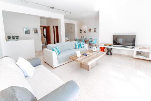 sala de estar con sofá y mesa en WealthyStays: Sunset Villa en Paralimni